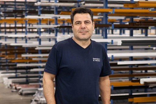 Ezzeddin Alshaikh Arbeiter in einer Werkstatt vor Aluminiumprofilen